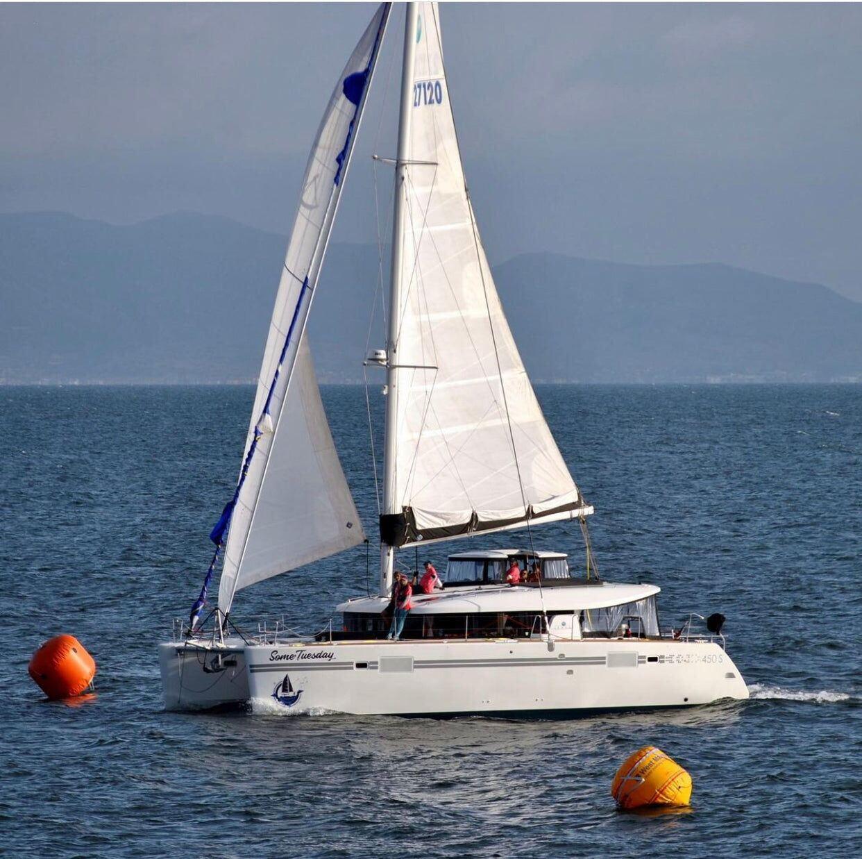Some Tuesday, a white catamaran, sailing with a fleet in the Newport to Ensenada race