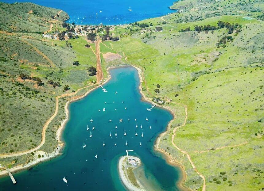 Two Harbors on Catalina, a low strip of buildings along the water with hills behind