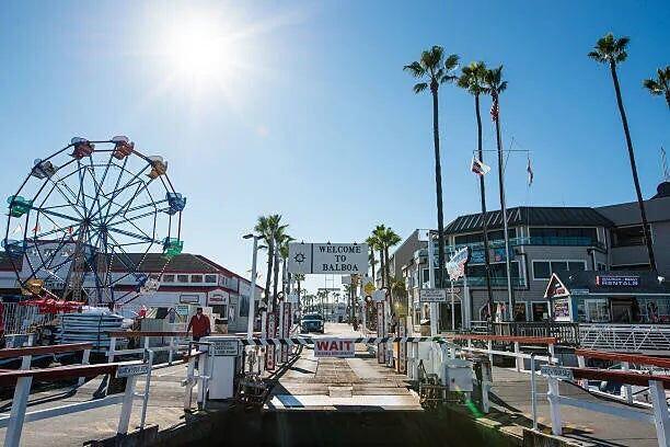 The Balboa Fun Zone arch over a street of shops, with a Ferris wheel behind it