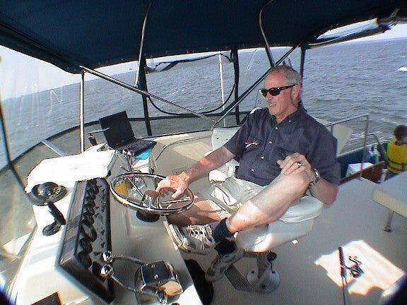 The stern of a white motor cruiser named Some Tuesday, tied at a wooden dock