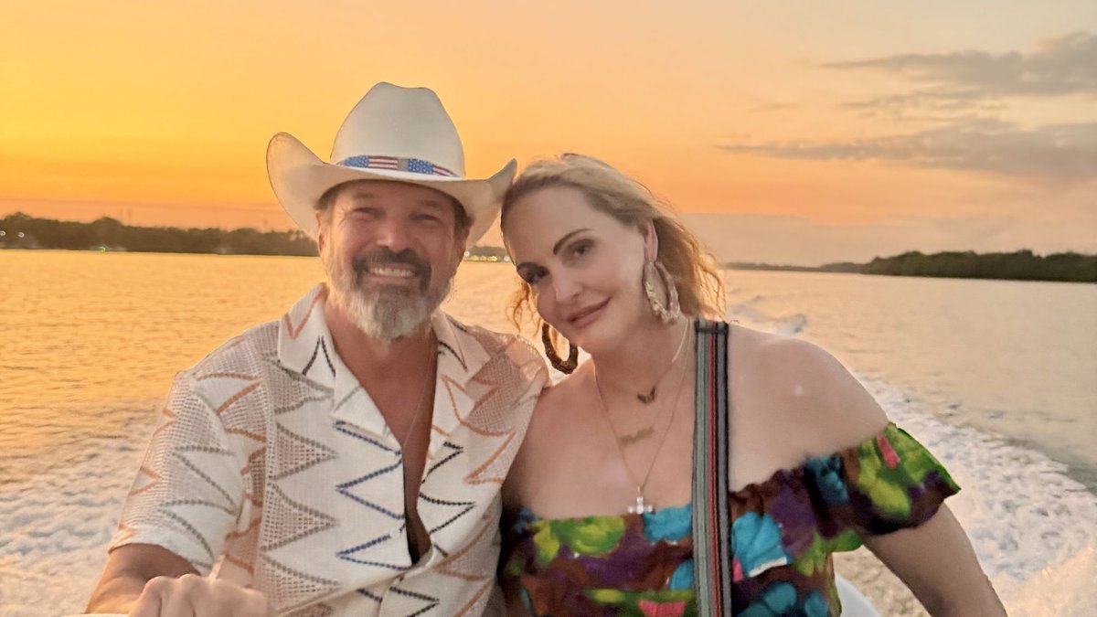 Meghan and Steve in the dinghy, with a gorgeous El Salvador sunset behind them