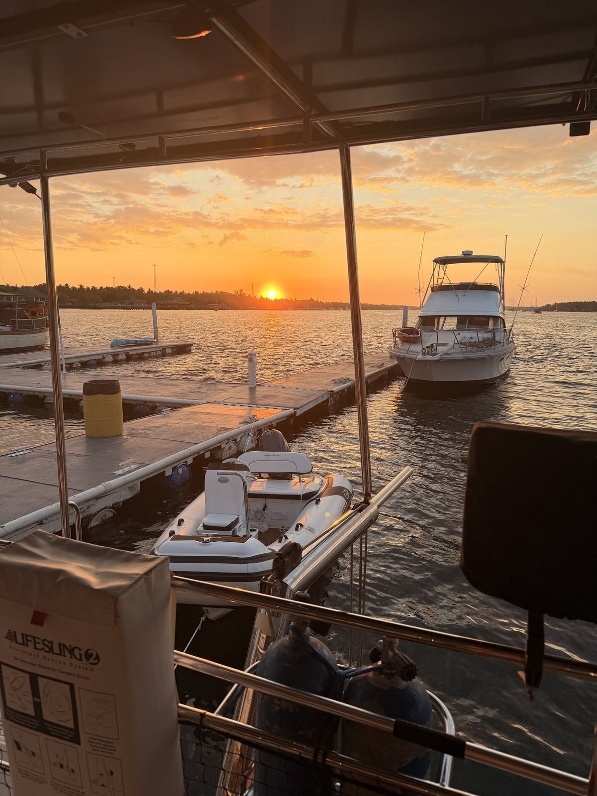 Sunset over the marina at Bahía del Sol, boat masts against an orange sky