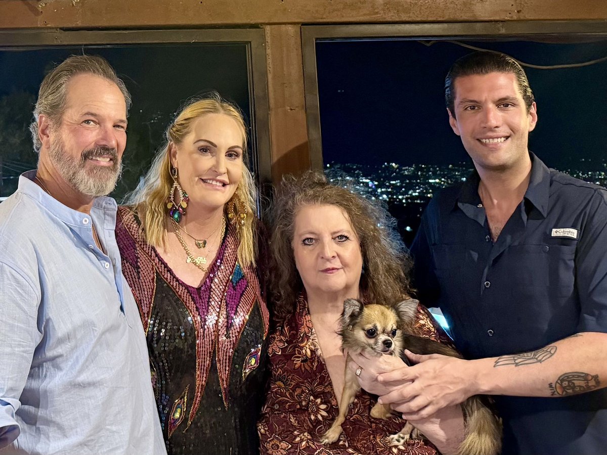Dinner at a table with Herbert, Jackie, Meghan, Steve, and Jackie's dog Rodolfo, city lights below the restaurant