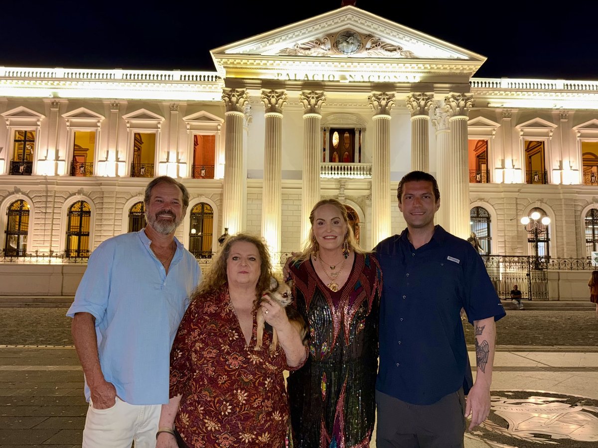 Captain Steve, Jackie, First Mate Meg, and Herbert standing in front of Palacio Nacional at night, left to right