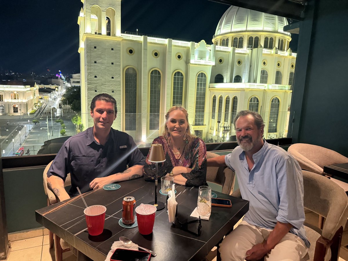 Herbert, First Mate Meg, and Captain Steve, left to right, with drinks on a rooftop bar across from the Metropolitan Cathedral in downtown San Salvador