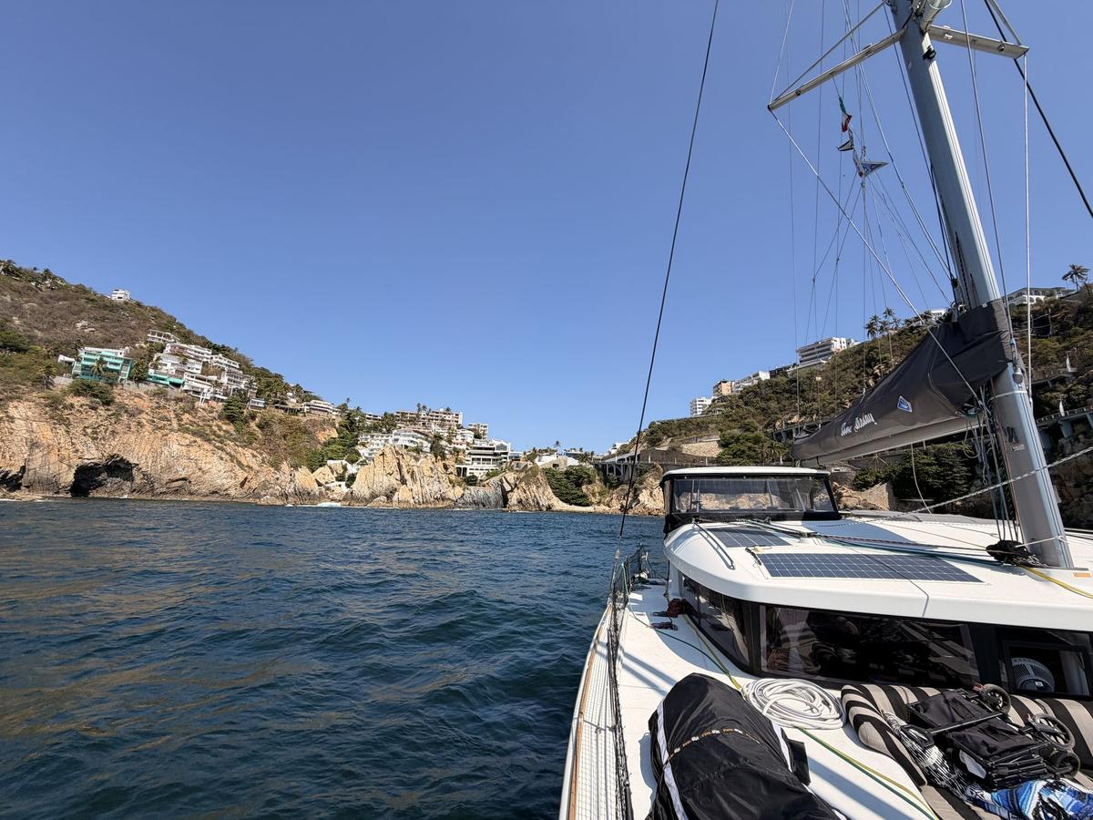 Boats anchored in a cove at Acapulco, with the cliffs of La Quebrada behind them