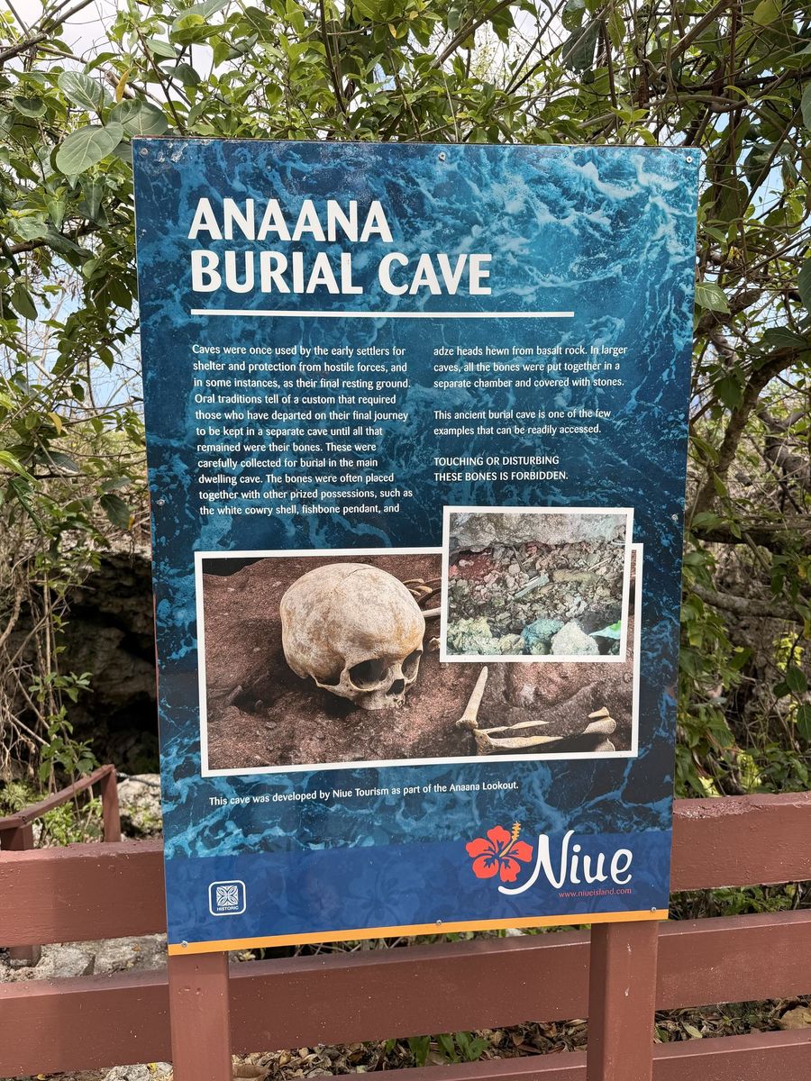 The blue Anaana Burial Cave sign, with a photograph of a skull and a note that touching the bones is forbidden