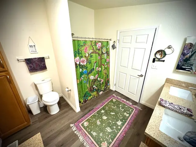 Bathroom with a botanical shower curtain and floral rug