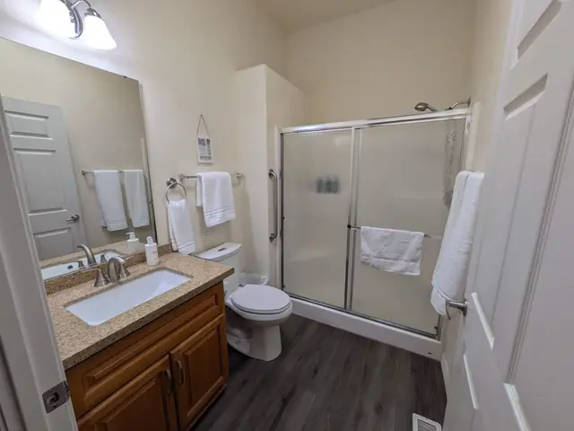 Bathroom with glass shower, vanity and fresh towels