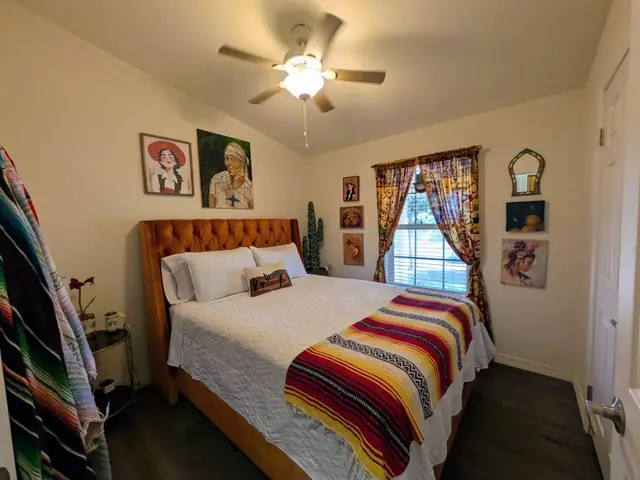 Bedroom with queen bed, serape throw and Western portraits