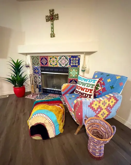 Patterned armchairs and woven baskets beside the tiled fireplace