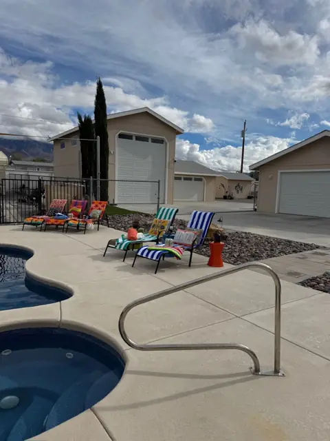 Private hot tub beside the pool with loungers along the deck