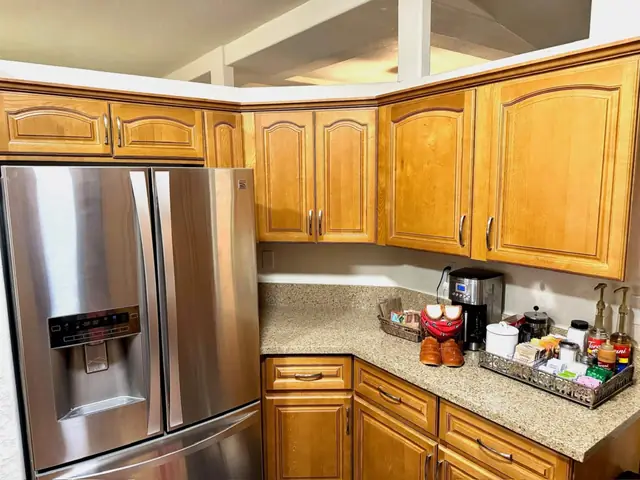 Full-size stainless refrigerator beside the coffee bar