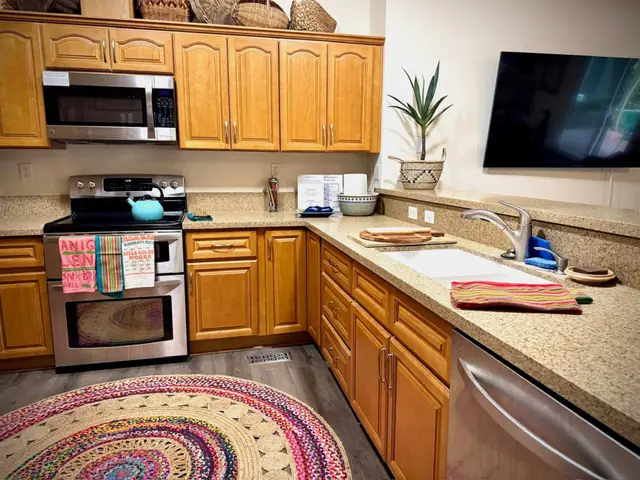 Kitchen with range, microwave and wall-mounted television