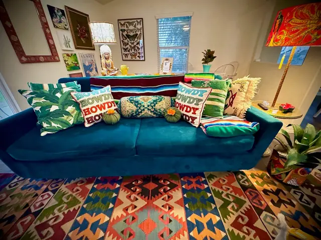 Living room with teal sofas, embroidered cushions and gallery wall