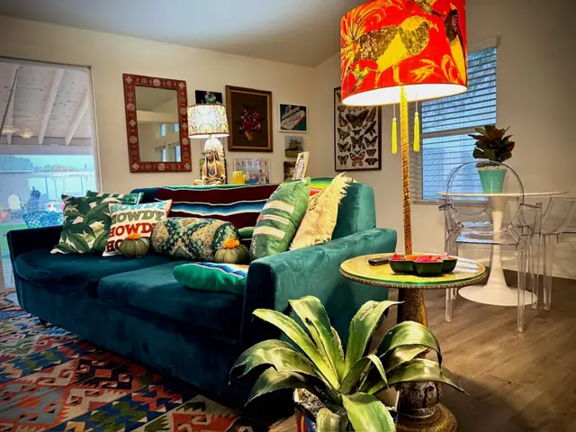 Teal velvet sofas, kilim rug and a hand-painted floor lamp in the living room