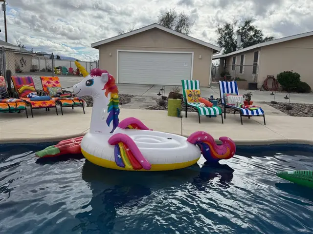 Pool with a unicorn float and shaded seating