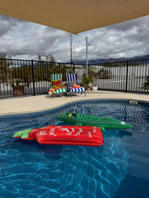 Pool with floats and mountain views past the fence line