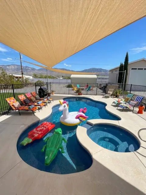 Shade sails over the pool and spa on a clear blue day