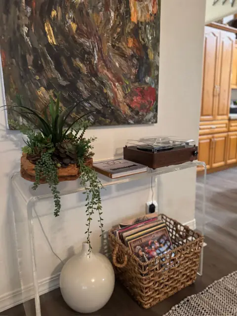 Record player and a stack of vinyl on a console table